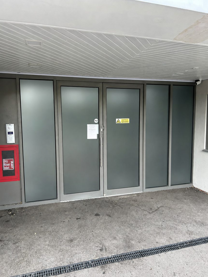 Frosted privacy window film on the communal entrance doors of a residential block of flats in West Sussex by Southpoint Window Films