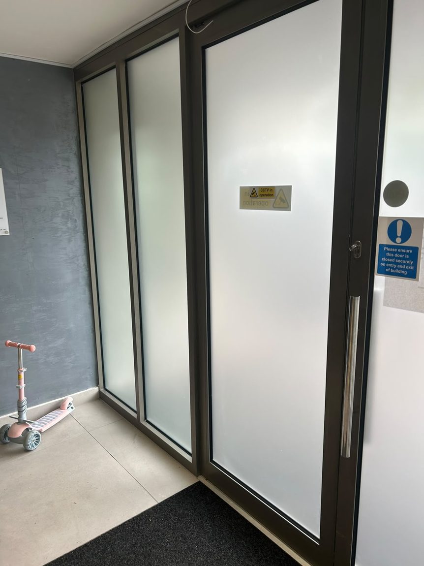 Frosted privacy window film on the communal entrance doors of a residential block of flats in West Sussex by Southpoint Window Films