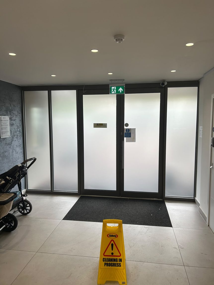 Frosted privacy window film on the communal entrance doors of a residential block of flats in West Sussex by Southpoint Window Films